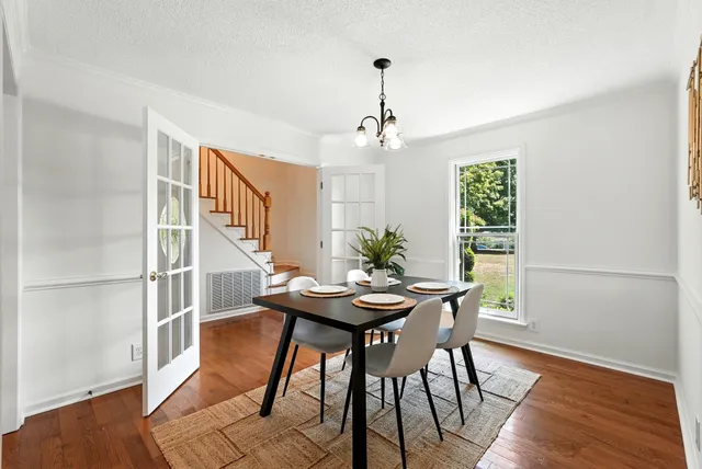 a kitchen with white cabinets and wooden floors