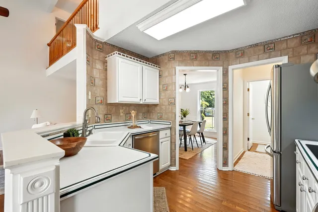 a dining room with furniture a chandelier and wooden floor
