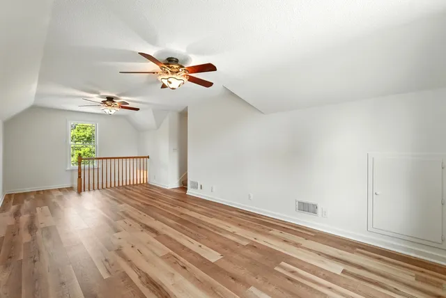 an empty room with ceiling fan and window