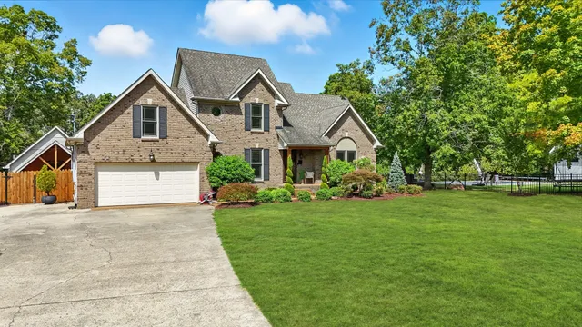 a front view of a house with a yard and trees