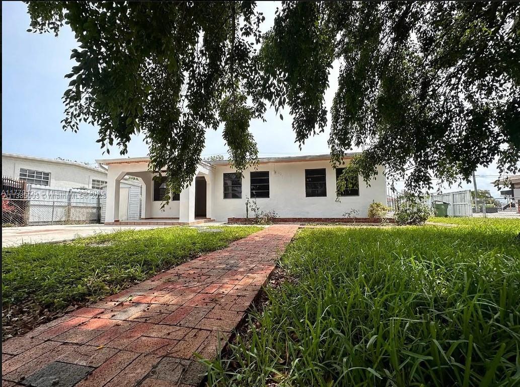 602 East 50th Street Hialeah, FL 33013 - Photo 1 of 20 a front view of a house with garden