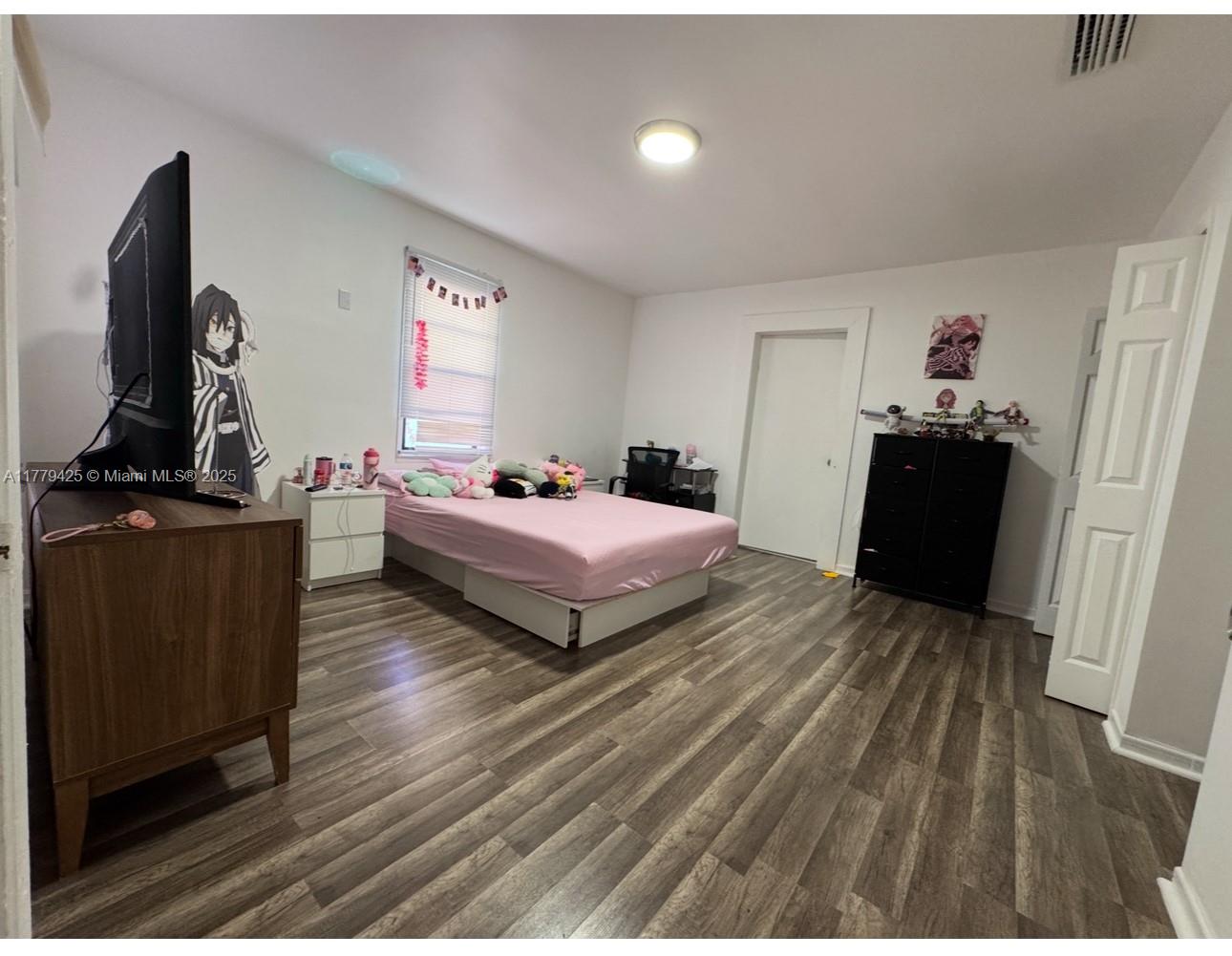 602 East 50th Street Hialeah, FL 33013 - Photo 10 of 20 a bedroom with a bed and wooden floor