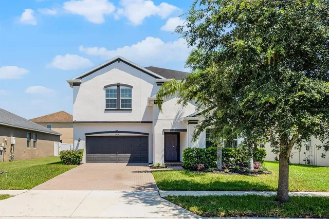 a front view of a house with a yard and garage