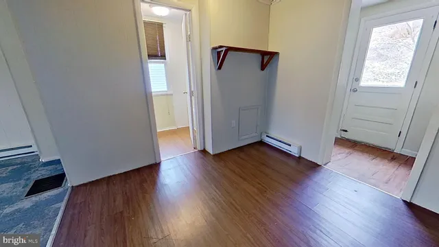 an empty room with wooden floor and a window