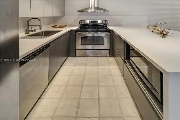 a kitchen with kitchen island stainless steel appliances a sink cabinets and refrigerator