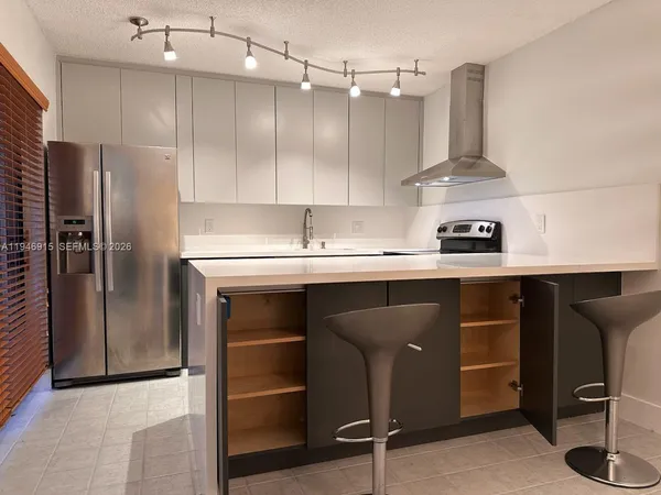 a bedroom with a bed and a flat tv screen on dresser