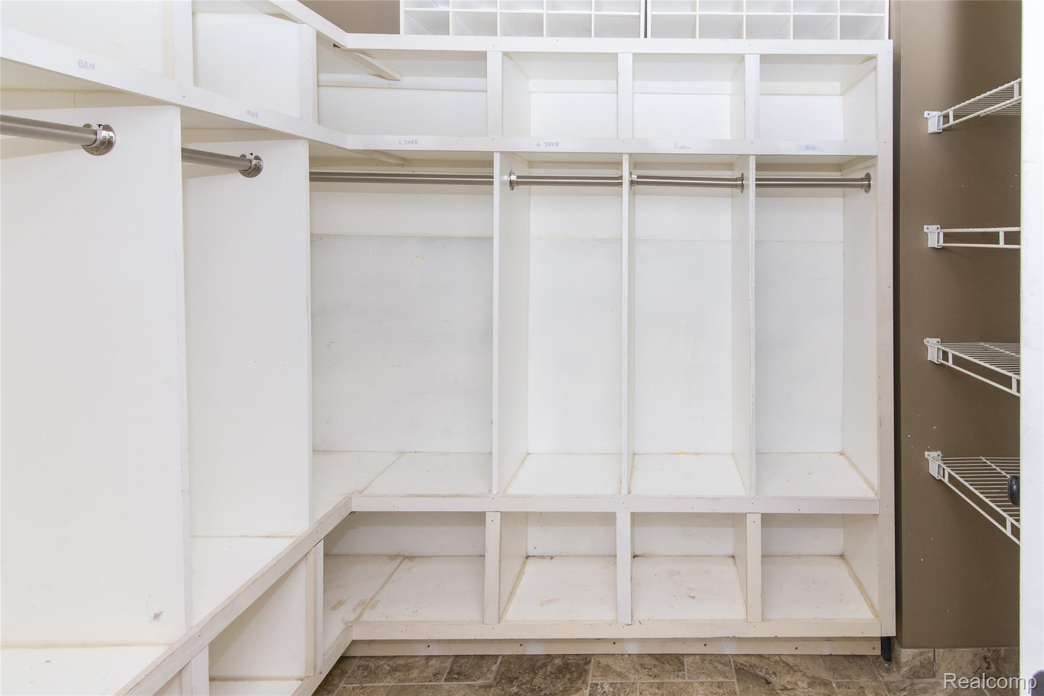 486 Sweet Briar Ridge Linden, MI 48451 - Photo 34 of 69 Built-in white cabinetry with hanging rods, integrated shelving units, and a tiled floor