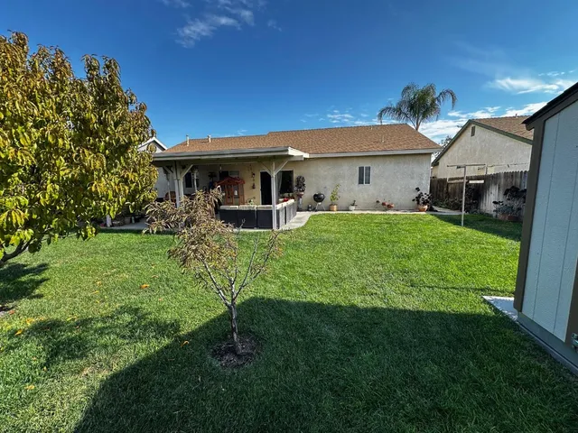 a front view of a house with a yard and trees