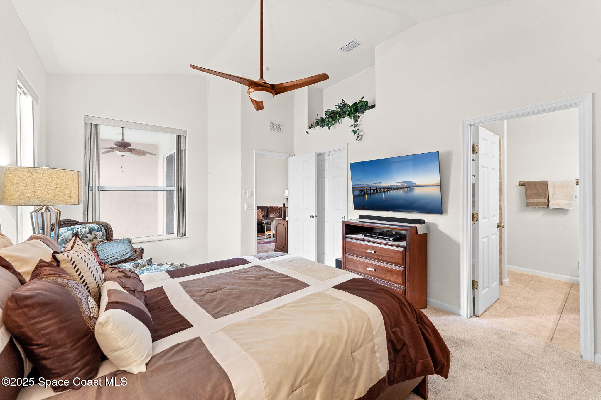 1910 Muirfield Way Southeast, Unit B Palm Bay, FL 32909 - Photo 12 of 34 a bedroom with a bed and a flat screen tv