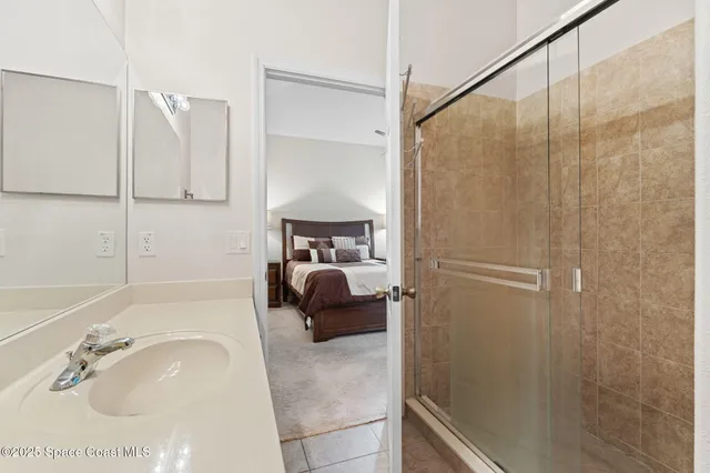 a en suite bathroom with a granite countertop sink and a mirror