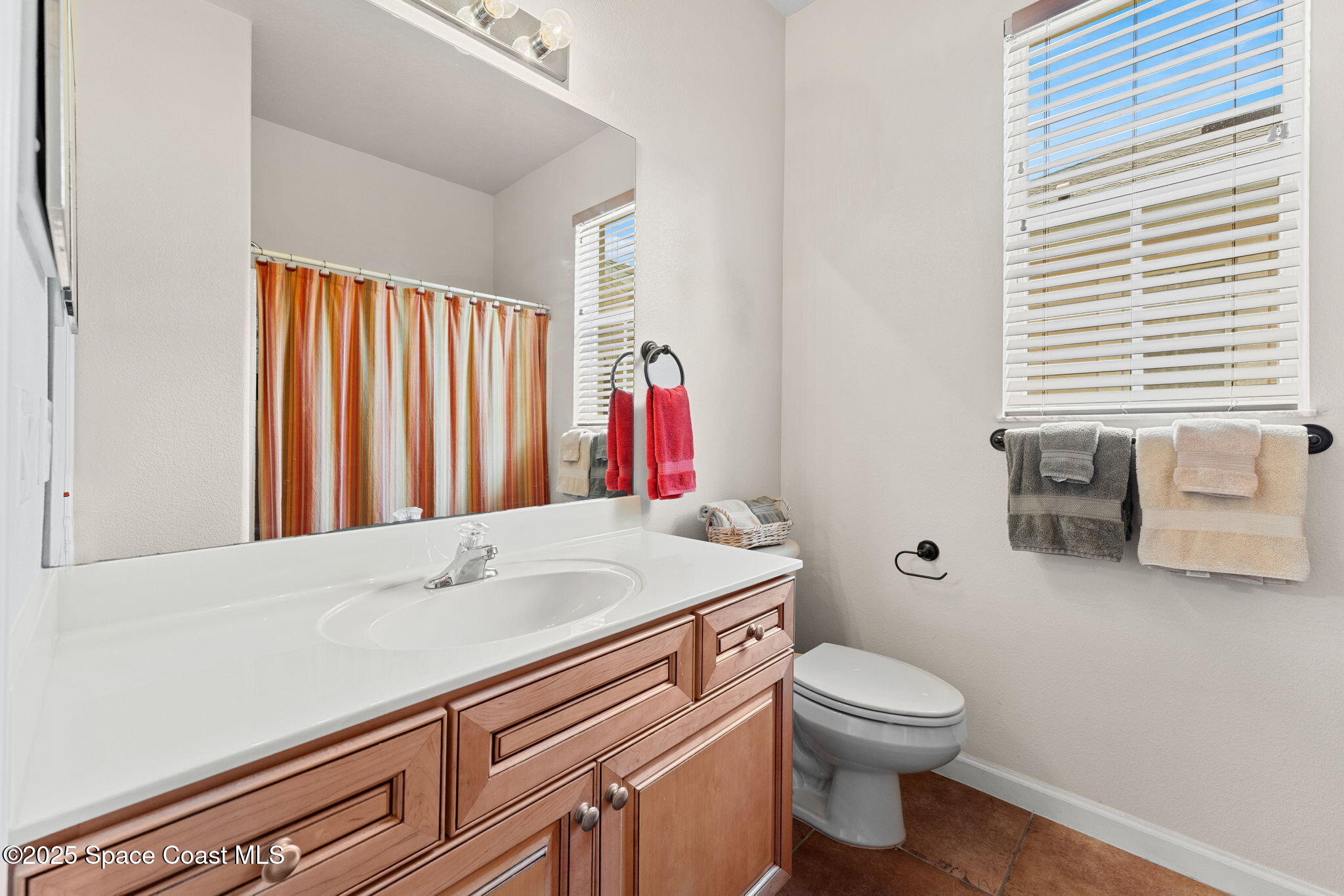 1910 Muirfield Way Southeast, Unit B Palm Bay, FL 32909 - Photo 16 of 34 a bathroom with a sink a toilet and shower curtain