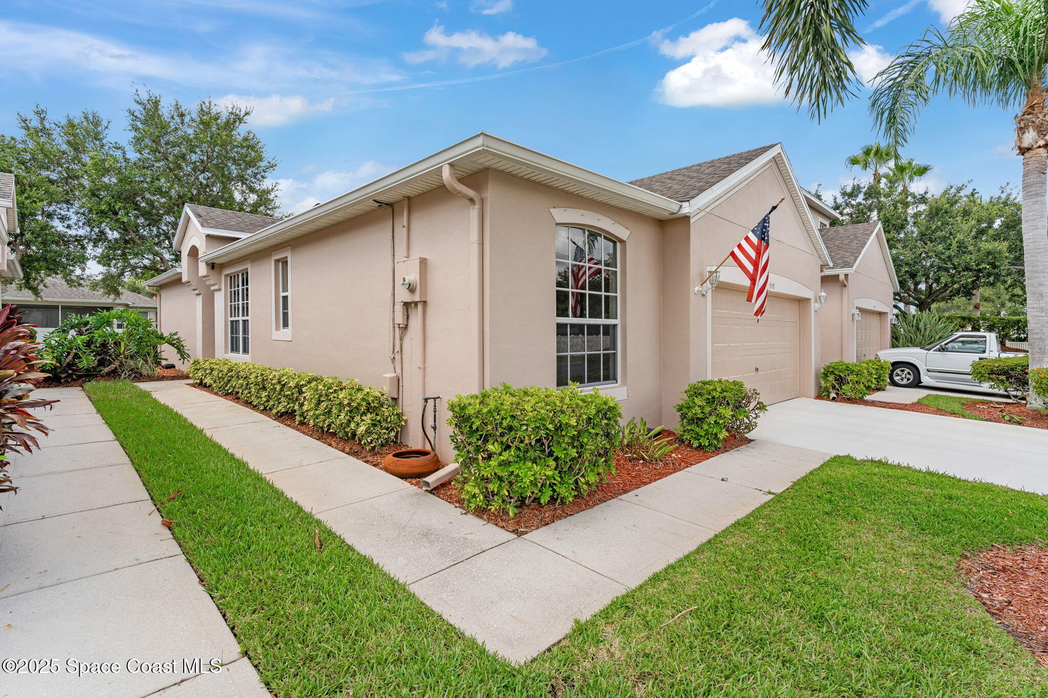 1910 Muirfield Way Southeast, Unit B Palm Bay, FL 32909 - Photo 21 of 34 a front view of a house with a yard and potted plants