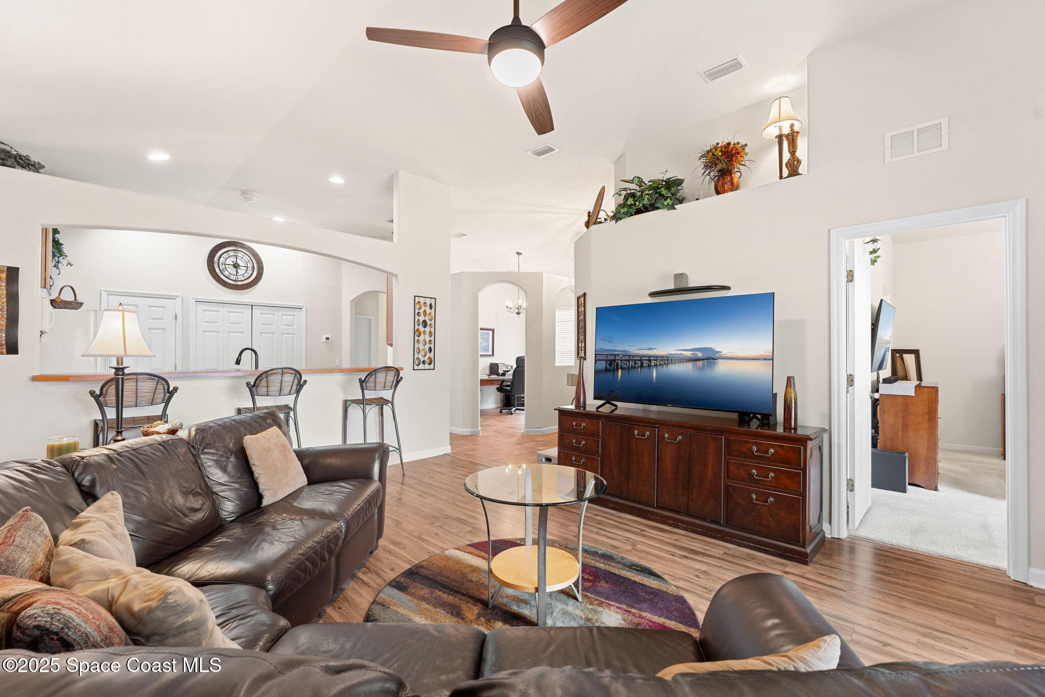 1910 Muirfield Way Southeast, Unit B Palm Bay, FL 32909 - Photo 6 of 34 a living room with furniture and a chandelier