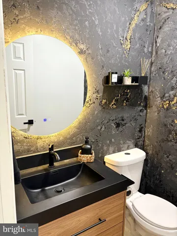 a bathroom with a sink a toilet and a mirror