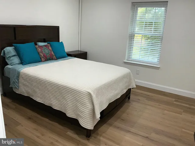 a large bed sitting in a bedroom next to a window