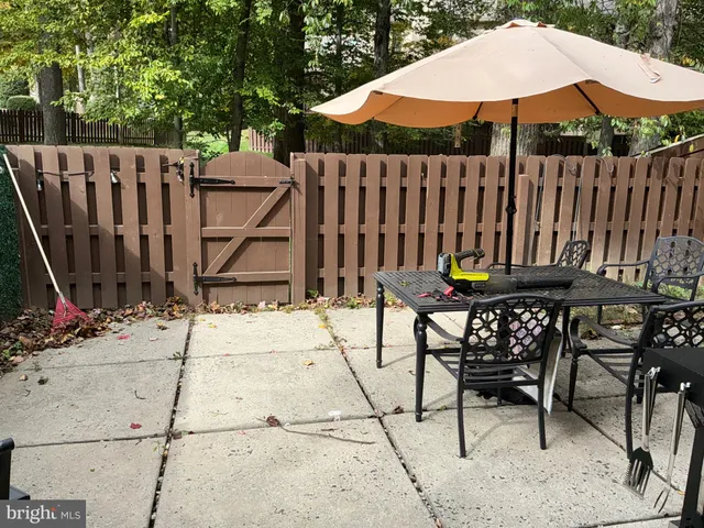 a view of wooden chairs and table under an umbrella