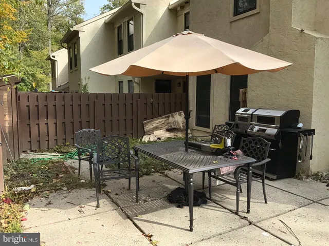 a view of a patio with a table and chairs under an umbrella