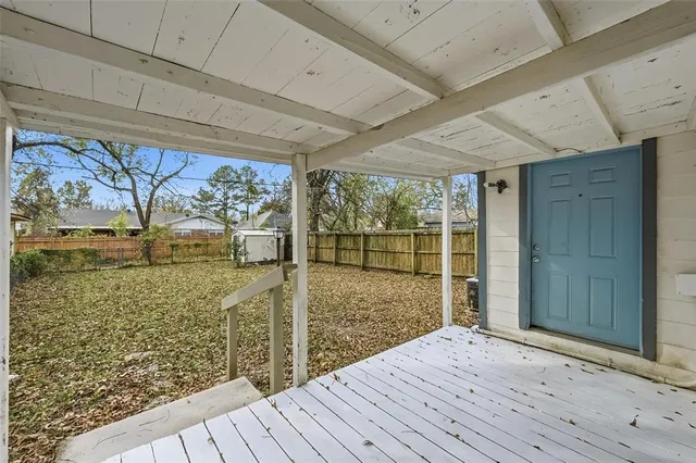 a view of a house with a small yard and wooden fence