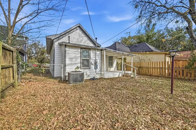 a view of a house with a large window and wooden fence