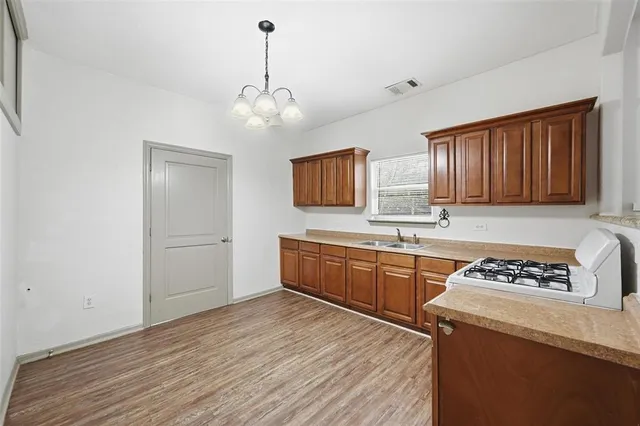 a kitchen with stainless steel appliances granite countertop wooden cabinets a stove a sink and dishwasher