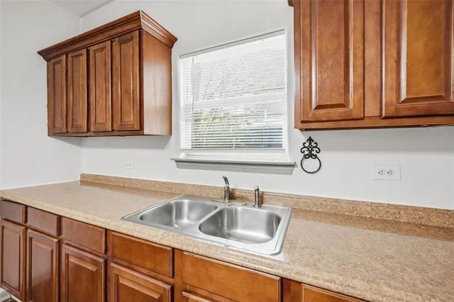a kitchen with a sink cabinets and a window