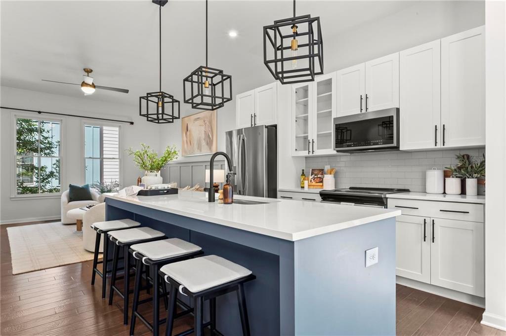 718 Needletail Way Atlanta, GA 30312 - Photo 7 of 44 a kitchen with stainless steel appliances a table chairs microwave and cabinets