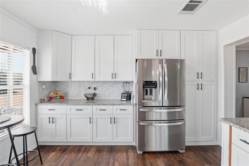 952 Gallilee Loop Lake City, FL 32024 - Photo 15 of 60 a kitchen with stainless steel appliances white cabinets and a wooden floor