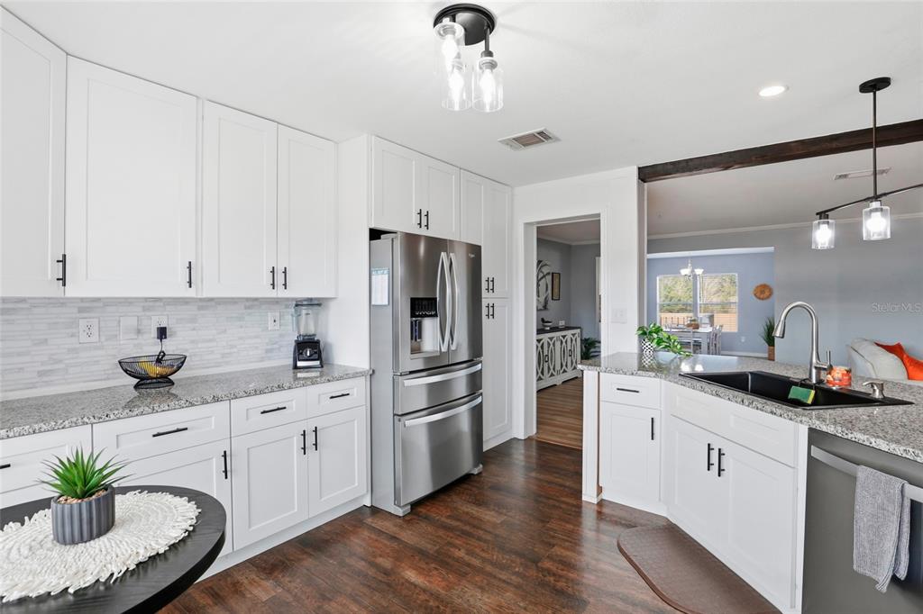 952 Gallilee Loop Lake City, FL 32024 - Photo 16 of 60 a kitchen with white cabinets and stainless steel appliances