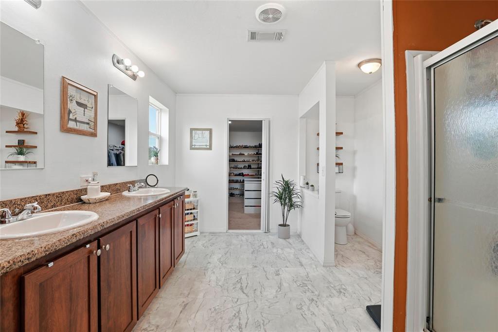 952 Gallilee Loop Lake City, FL 32024 - Photo 35 of 60 a spacious bathroom with a granite countertop sink shower and a mirror