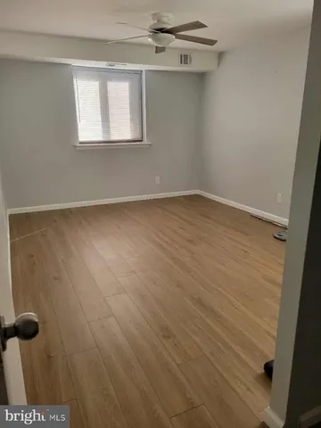 a view of a room with wooden floor and mirror