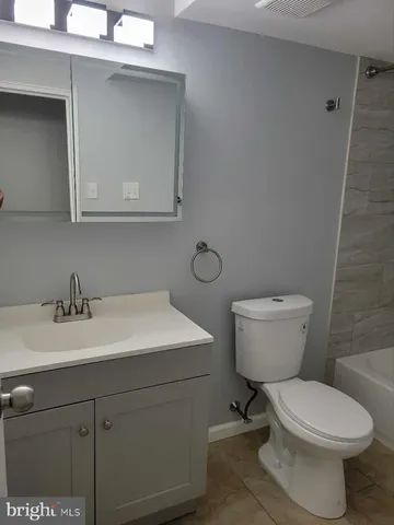 a bathroom with a toilet a sink a vanity and mirror