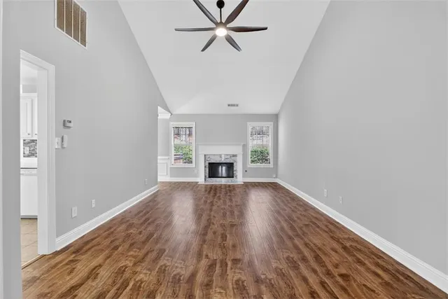 a view of empty room with wooden floor fireplace and windows