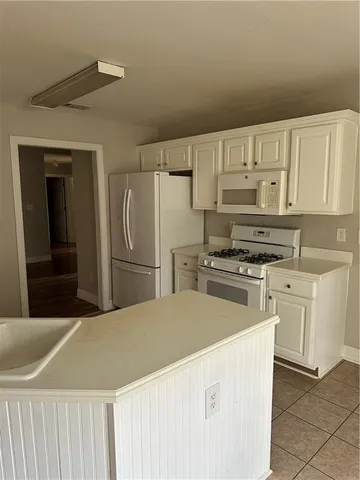 a kitchen with kitchen island white cabinets and stainless steel appliances