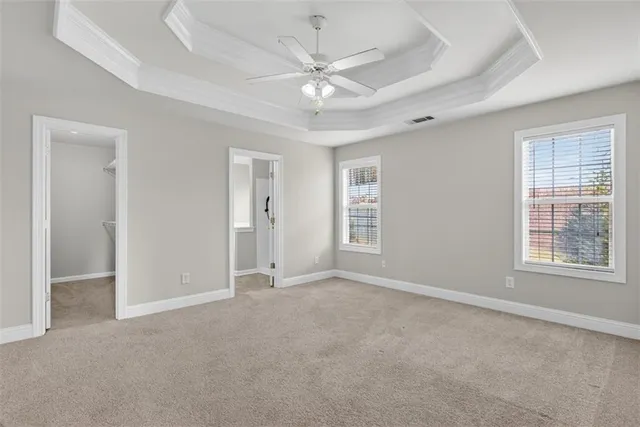 an empty room with windows and fan