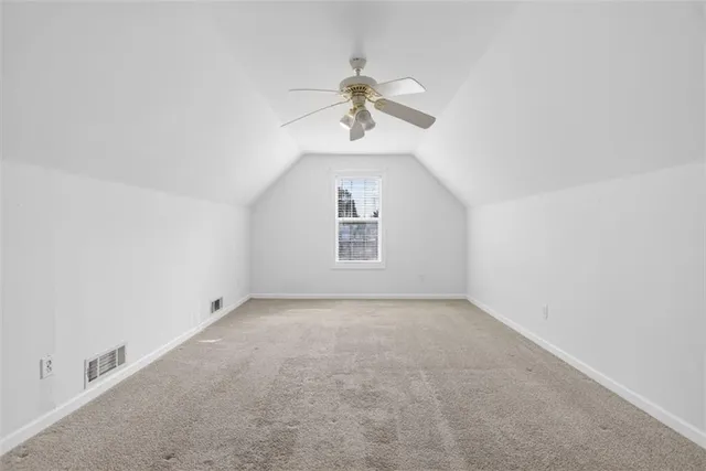 a view of a room with a ceiling fan and window
