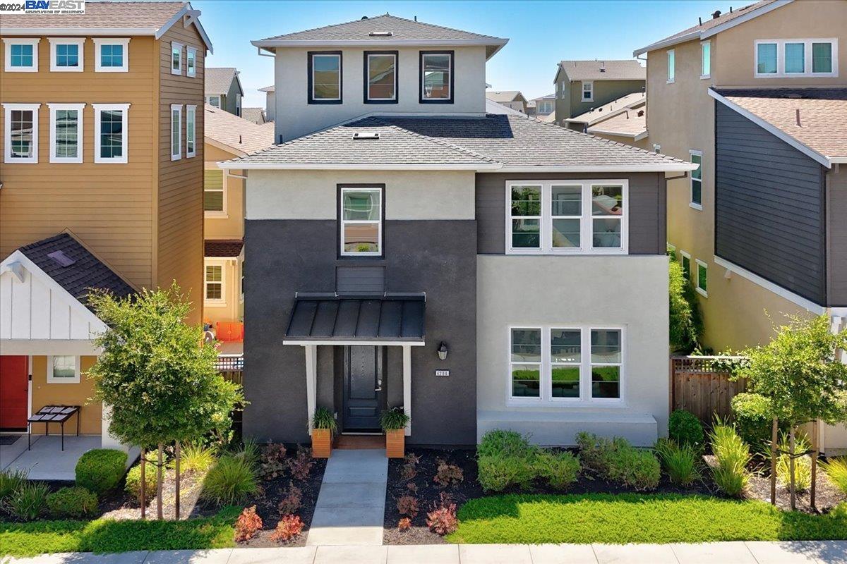 a front view of a house with a yard and potted plants
