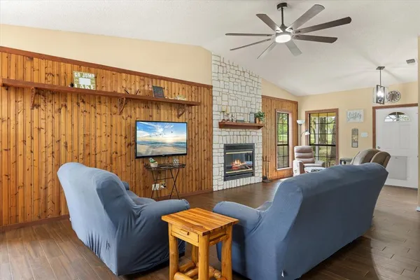a living room with furniture a ceiling fan and a flat screen tv