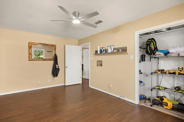 a view of a livingroom with wooden floor and a ceiling fan