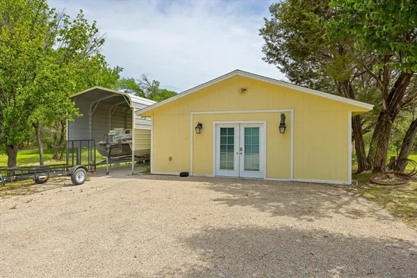 a view of a house with backyard and trees