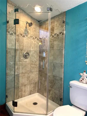 a bathroom with a shower a toilet and a sink