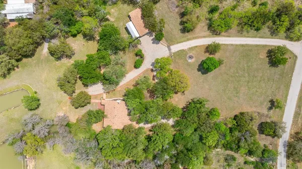 an aerial view of a house with a yard and lake view