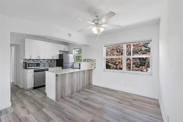a kitchen with a refrigerator and white cabinets