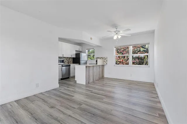 a view of a kitchen with wooden floor and a ceiling fan