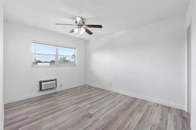a view of room with wooden floor and ceiling fan