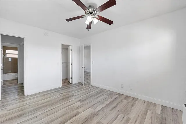 wooden floor in an empty room with a fan
