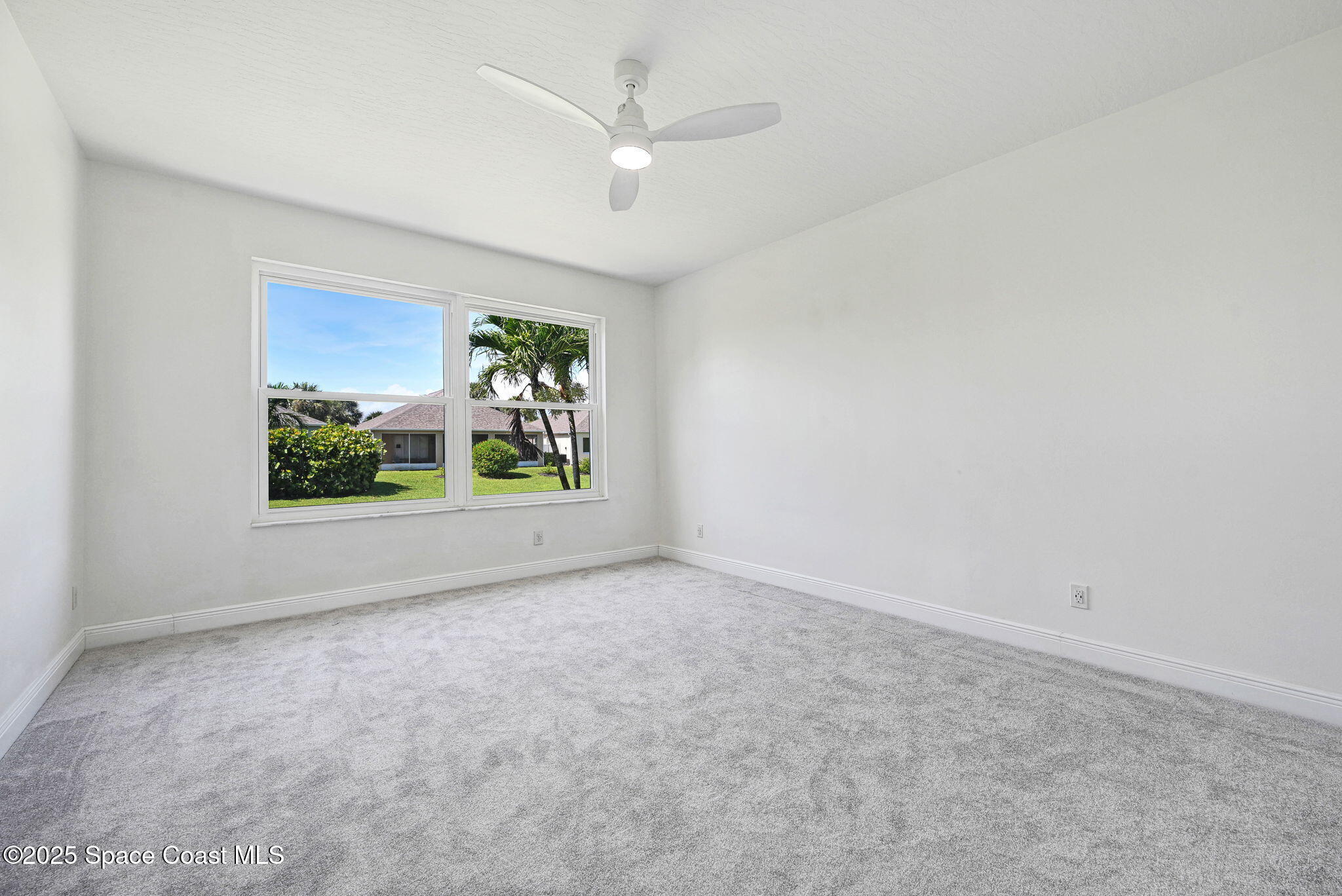 165 Calico Lane Indialantic, FL 32903 - Photo 11 of 25 an empty room with windows and ceiling fan