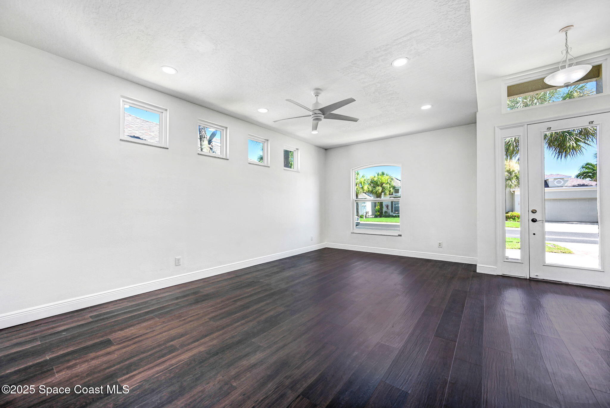 165 Calico Lane Indialantic, FL 32903 - Photo 5 of 25 an empty room with wooden floor and windows