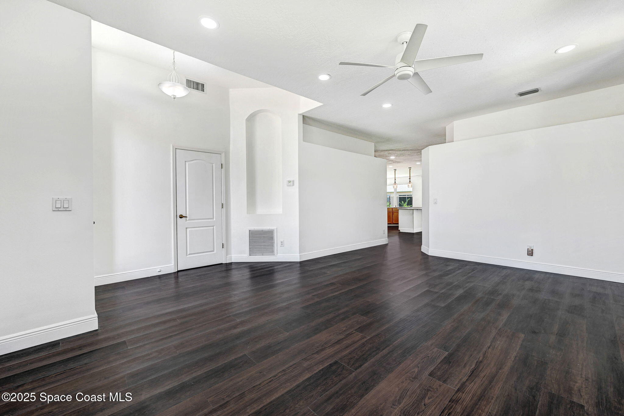 165 Calico Lane Indialantic, FL 32903 - Photo 6 of 25 an empty room with wooden floor and ceiling fan