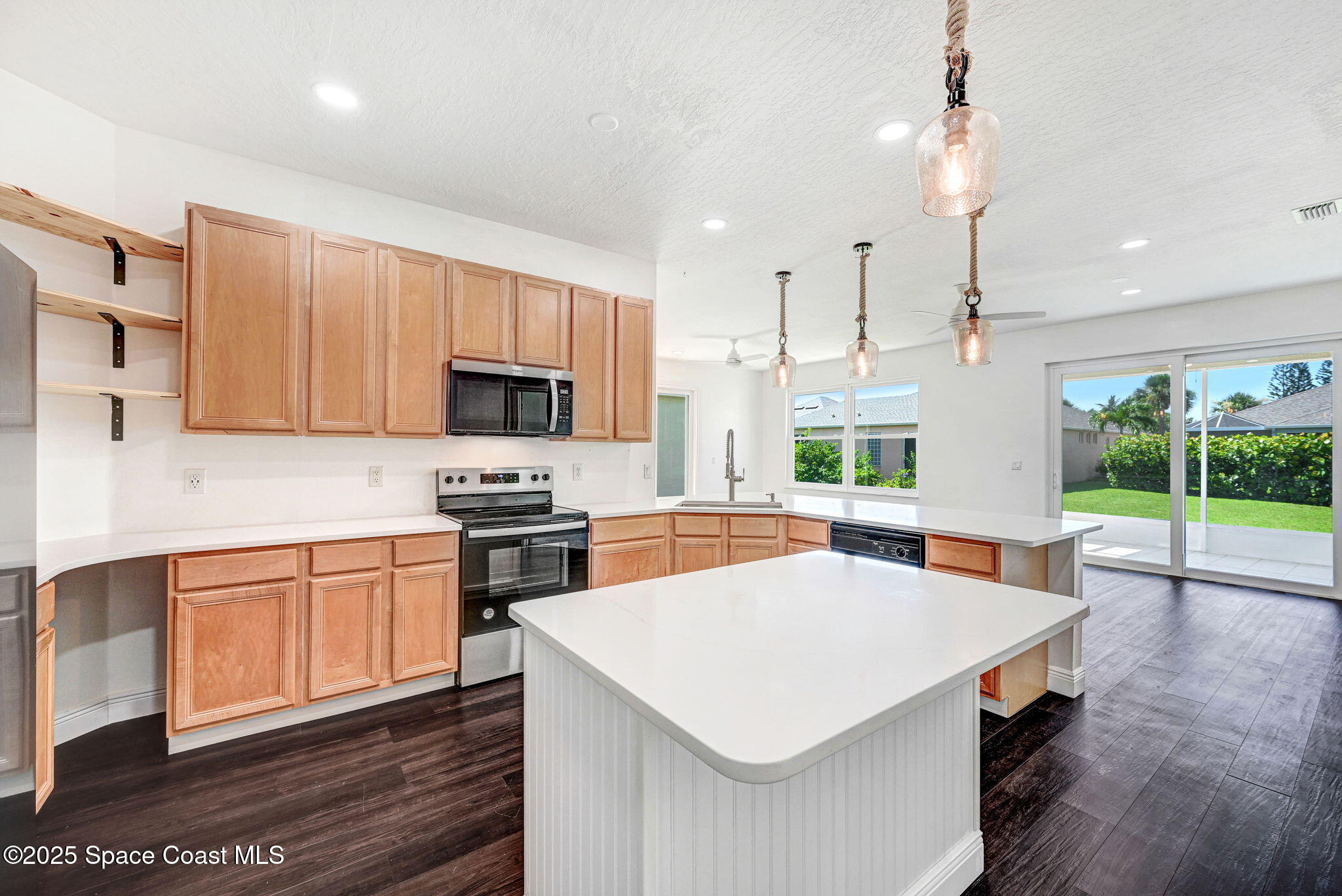 165 Calico Lane Indialantic, FL 32903 - Photo 8 of 25 a kitchen with stainless steel appliances a stove a sink a microwave a refrigerator and cabinets