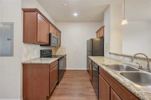 a kitchen with stainless steel appliances granite countertop a sink and a refrigerator